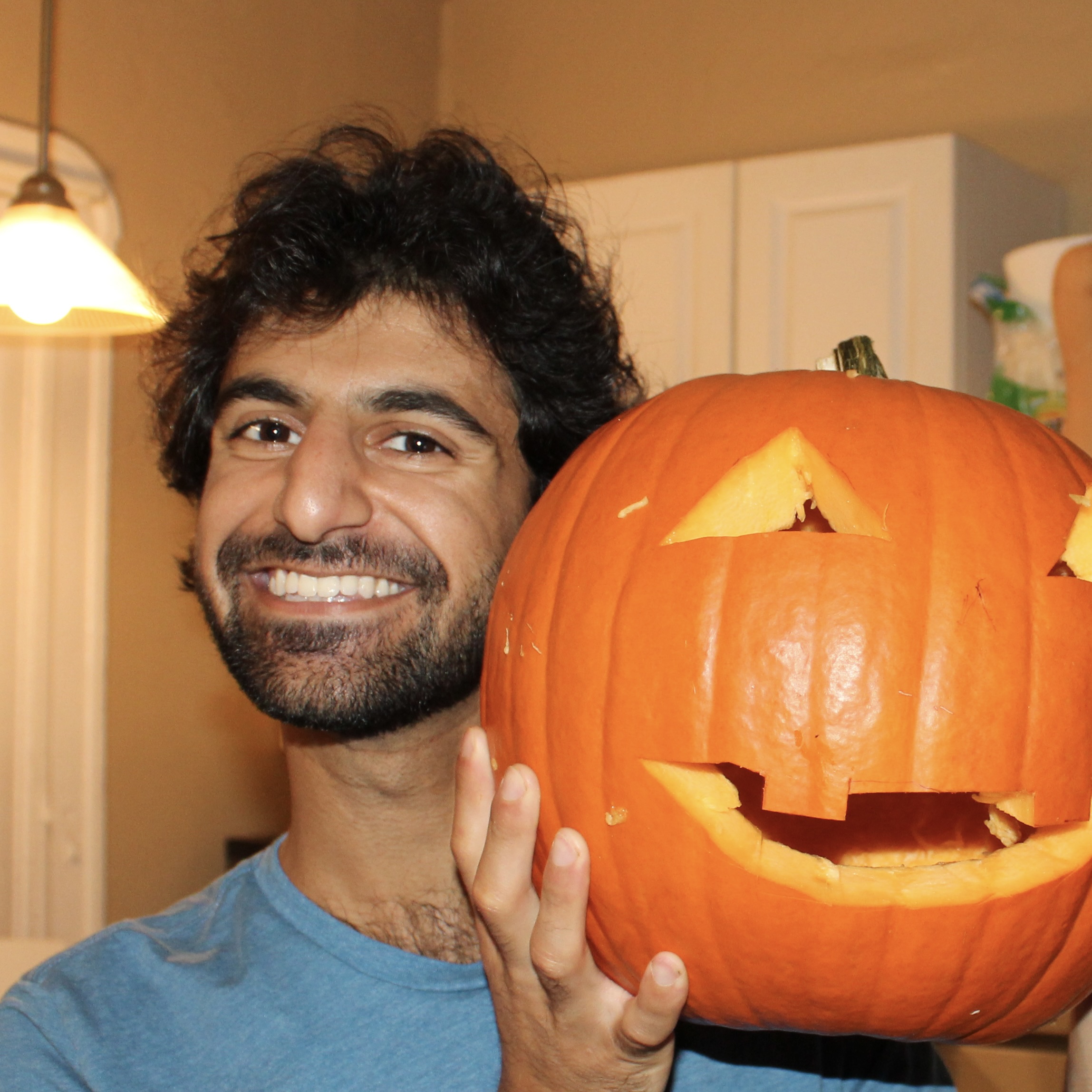 A portrait of the author holding a carved pumpking by his head.